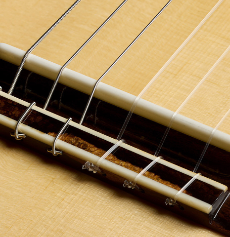 The bridge, tie-block and saddle of a 2026 Wolfgang Jellinghaus "Signature SP/SP" double top classical guitar made of spruce and ziricote