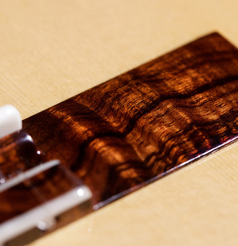 The bridge of a 2023 Wolfgang Jellinghaus &quot;Signature SP/SP 640&quot; classical guitar made of spruce and granadillo.