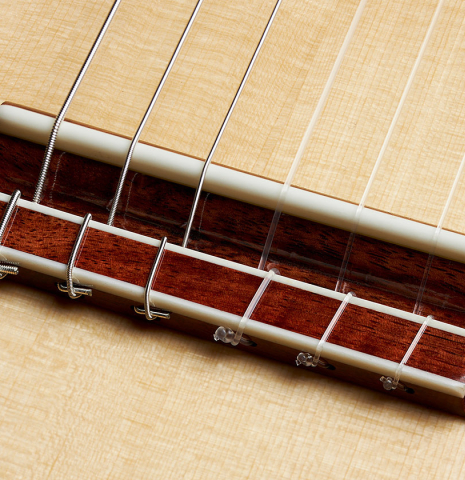 The bridge, tie-block and saddle of a 2024 Wolfgang Jellinghaus "Signature SP/SP 640" classical guitar made of spruce and granadillo