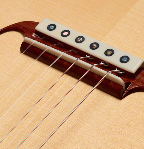 The bridge, tie-block and saddle of a Wolfgang Jellinghaus "La Romantica 1a - clear" classical guitar made of spruce and maple