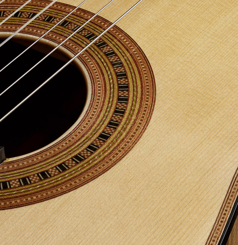 The top and rosette detail of a Wolfgang Jellinghaus “Torres 43” classical guitar made of spruce and maple and clear finish