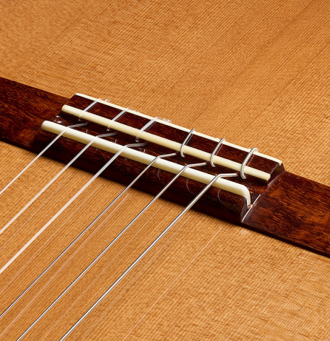 The bridge, tie-block and saddle of a Wolfgang Jellinghaus "Signature CD/SP 640" classical guitar made of cedar and Granadillo