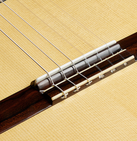 The bridge, tie-block and saddle of a Wolfgang Jellinghaus "1912 Ex-Segovia 630" classical guitar made of spruce and ziricote