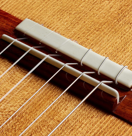 The bridge, tie-block and saddle of a Wolfgang Jellinghaus “Torres FE 13” classical guitar with antiqued finish, made of spruce and Indian rosewood