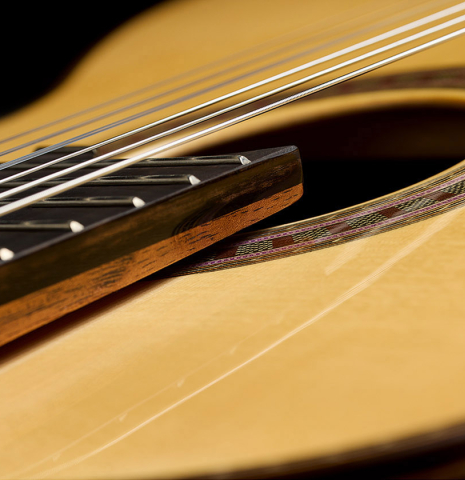 The elevated fingerboard of a Wolfgang Jellinghaus "Signature SP/CD 640" classical guitar made of spruce/cedar and ziricote