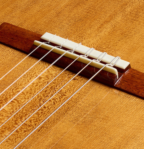 The bridge, tie-block and saddle of a Wolfgang Jellinghaus "Torres SE 02" classical guitar made with spruce and cypress