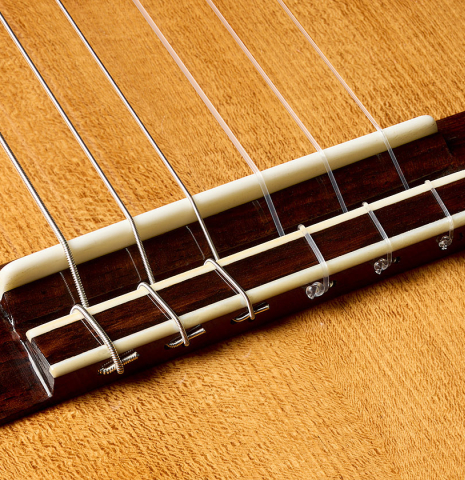 The bridge, tie-block and saddle of a 2025 Wolfgang Jellinghaus "1912 Ex-Segovia A" classical guitar made of spruce and Indian rosewood
