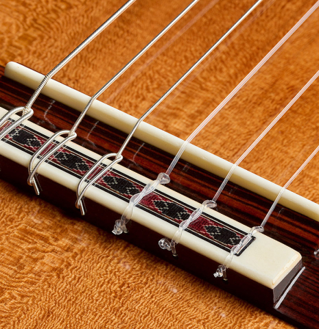 The bridge, tie-block and saddle of a Wolfgang Jellinghaus "Friederich - aged" classical guitar made of cedar and Indian rosewood