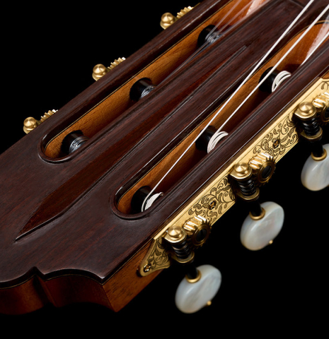 The carved headstock veneer of a Wolfgang Jellinghaus "Friederich - aged" classical guitar made of cedar and Indian rosewood