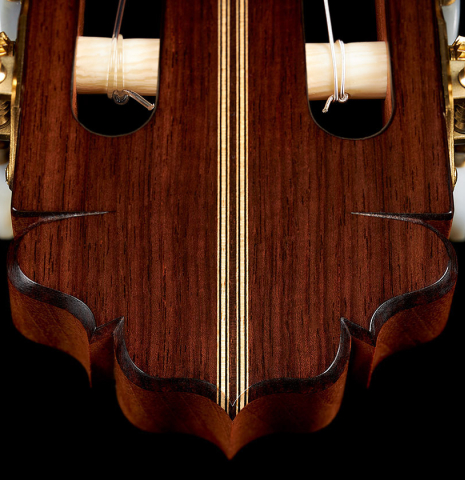 The headstock veneer and purfling of a 2023 Francisco Jimenez classical guitar made of cedar and Indian rosewood
