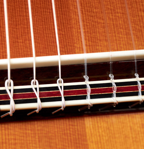 The bridge and saddle of a 2022 So Kimishima “Stella” classical guitar made with cedar and Indian rosewood