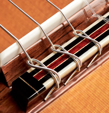 The bridge and saddle of a 2023 So Kimishima “Stella” classical guitar made with cedar and Indian rosewood