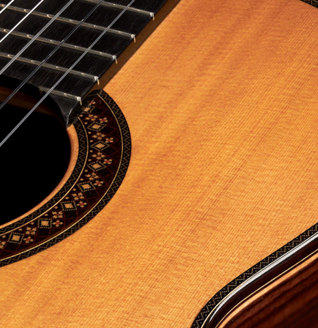 The close-up of the top and rosette of a 2023 So Kimishima “Stella” classical guitar made with cedar and Indian rosewood