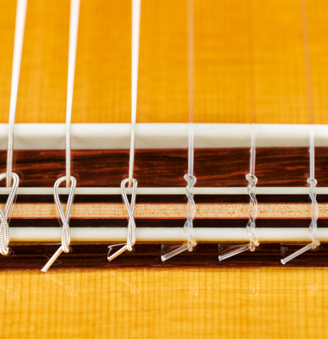 The bridge, tie-block and saddle of a 2023 So Kimishima “Stella” classical guitar made with cedar and Indian rosewood
