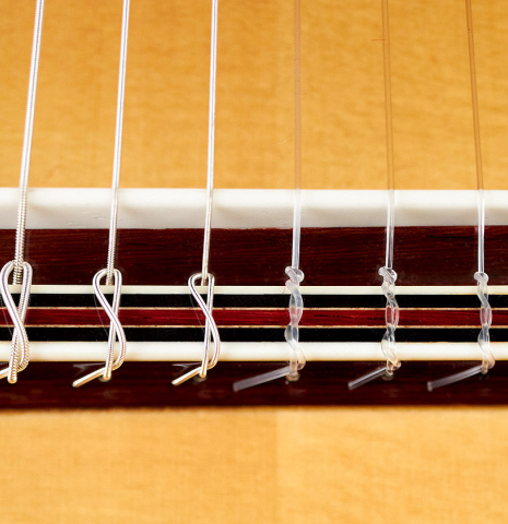 The bridge and saddle of a 2022 So Kimishima “Stella” classical guitar made with spruce and Indian rosewood