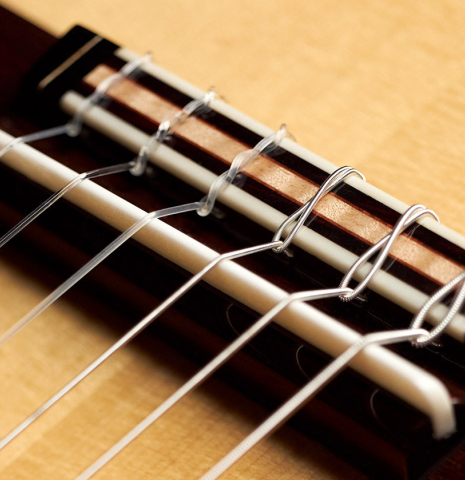 The bridge and saddle of a 2023 So Kimishima “Stella” classical guitar made with spruce and Indian rosewood