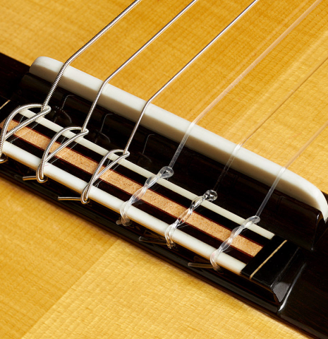 The bridge, tie-block and saddle of a 2023 So Kimishima “Stella” classical guitar made with spruce and Indian rosewood