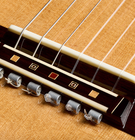 The bridge, tie-block and saddle of a 2026 So Kimishima “Sol” classical guitar made of cedar and African rosewood