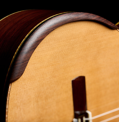 The soundboard and arm rest of a 2026 So Kimishima “Sol” classical guitar made of cedar and African rosewood