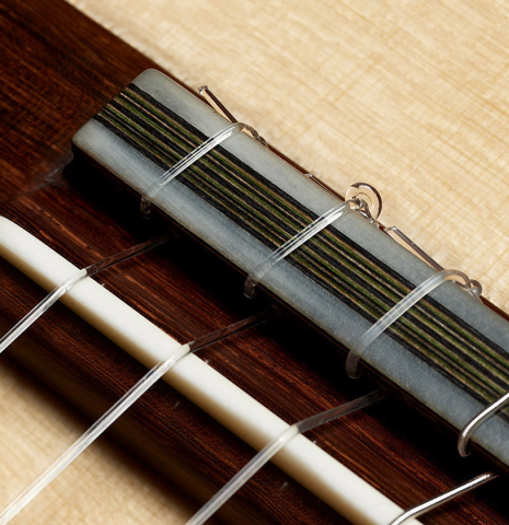 The bridge, tie-block and saddle of a 2025 Evan Kingma classical guitar made of spruce and ziricote