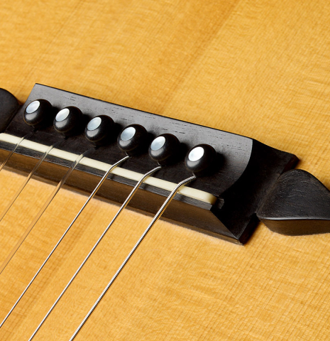 The bridge and saddle of a 1998 Bernhard Kresse "Panormo" classical guitar made of spruce and CSA rosewood