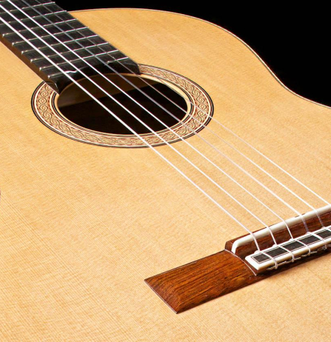 The soundboard and bridge of a 2015 Zoran Kuvac classical guitar made with cedar and African rosewood