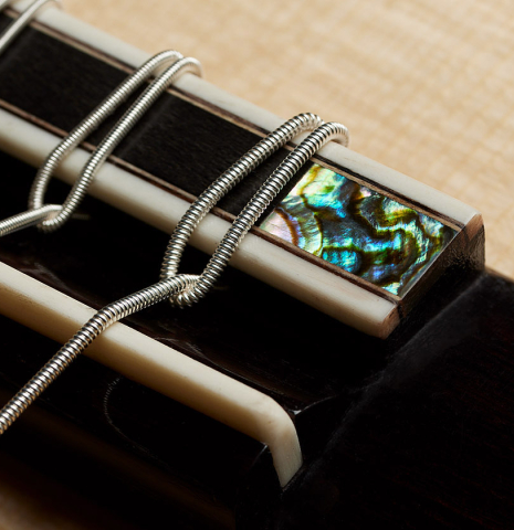 The bridge, tie-block and saddle of a 2024 Zoran Kuvac "Double Top" classical guitar made of spruce and CSA rosewood