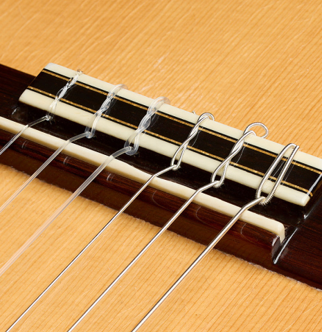 The bridge, tie-block and saddle of a 2004 Bert Kwakkel "Merula 640" classical guitar made of spruce and CSA rosewood