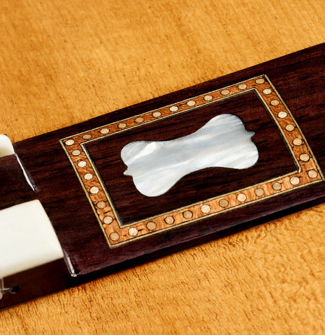 The mother-of-pearl inlays on the wings of the bridge of a La Cañada "Model 17A" classical guitar made of spruce and maple