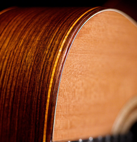 The soundboard and side of a 2022 Paula Lazzarini classical guitar made of cedar and Indian rosewood