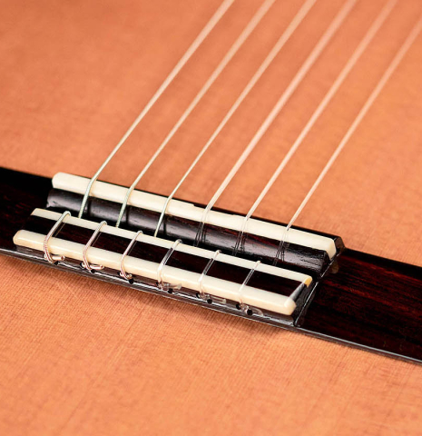 The soundboard, bridge and tie-block of a 2021 Paula Lazzarini classical guitar made of cedar and Indian rosewood