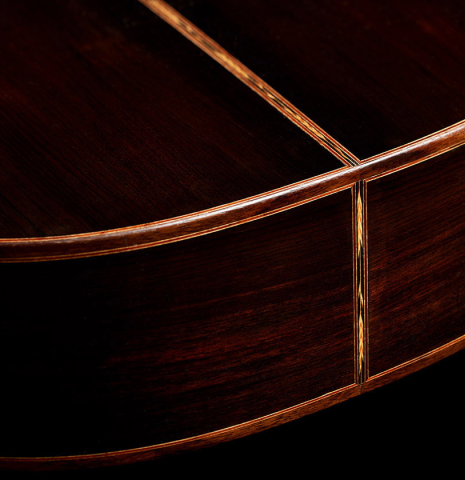 The back and sides at the foot of a 2014 Garrett Lee classical guitar made of spruce and CSA rosewood