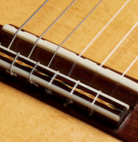 The bridge, tie-block and saddle of a 2014 Garrett Lee classical guitar made of spruce and CSA rosewood