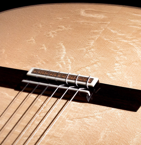 The bearclaw spruce top and bridge of a 2023 Valerio Licari classical guitar made with spruce and Indian rosewood