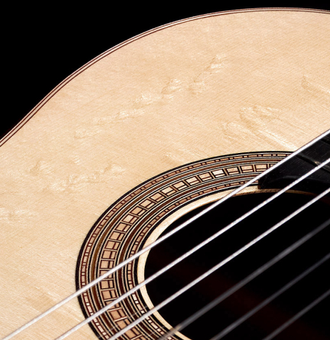 Closeup of the bearclaw spruce top and rosette of a 2023 Valerio Licari classical guitar made with spruce and Indian rosewood