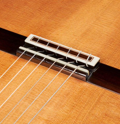 The bridge, tie-block and saddle of a 2024 Valerio Licari "Albayzín" classical guitar made of cedar and Indian rosewood