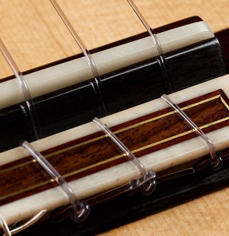 The bridge, tie-block and saddle of a 2021 Valerio Licari "Albayzín" classical guitar made of spruce and Indian rosewood