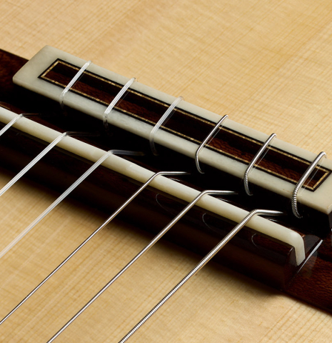 The bridge, tie-block and saddle of a 2025 Valerio Licari "Lesna - Special Edition" classical guitar made of spruce and ziricote