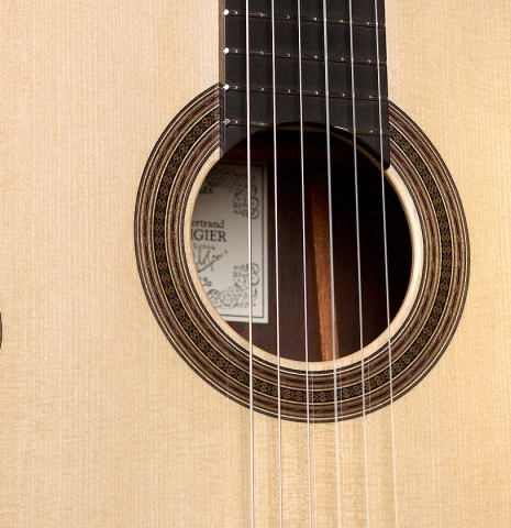 The soundboard of a 2021 Bertrand Ligier classical guitar made of spruce and African rosewood