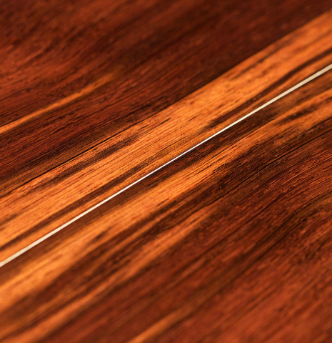 A close-up of the back of a 2021 Bertrand Ligier classical guitar made of spruce and African rosewood
