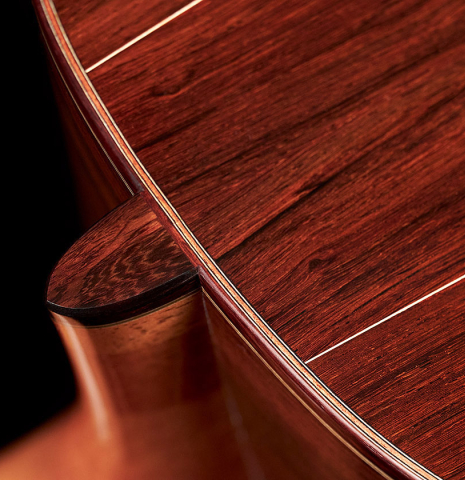 A close-up of the heel of a 2023 Bertrand Ligier classical guitar made of spruce and African rosewood