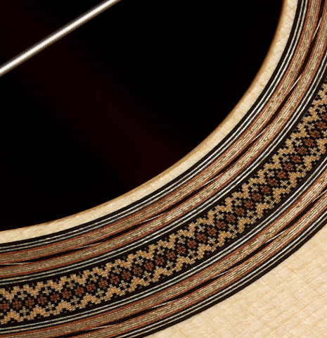 A close-up of the rosette of a 2023 Bertrand Ligier classical guitar made of spruce and African rosewood