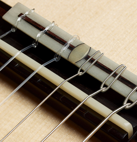The bridge, tie-block and saddle of a 2024 Bertrand Ligier classical guitar made of spruce and African rosewood