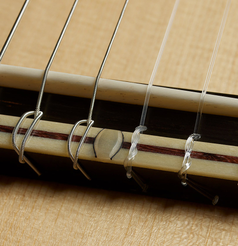The bridge, tie-block and saddle of a 2025 Bertrand Ligier classical guitar made of spruce and African rosewood