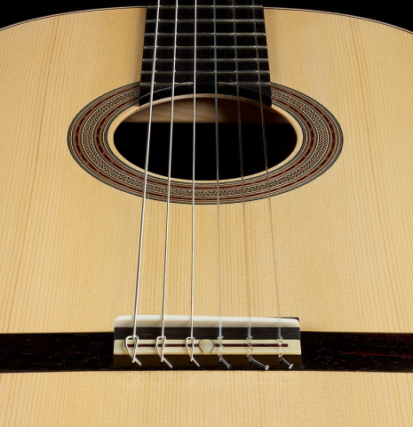 The soundboard and bridge of a 2025 Bertrand Ligier classical guitar made of spruce and African rosewood