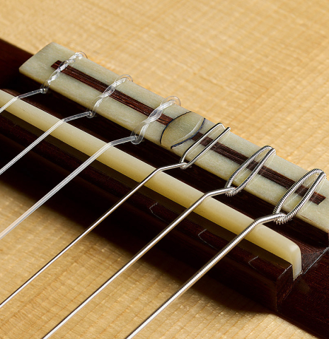 The bridge, tie-block and saddle of a 2026 Bertrand Ligier classical guitar made of spruce and African rosewood