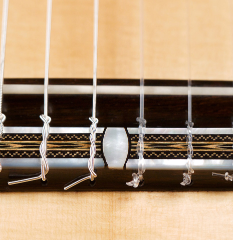 The bridge and saddle of a 2021 Luigi Locatto classical guitar made of spruce and CSA rosewood
