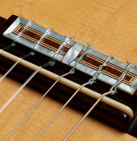 The bridge, tie-block and saddle of a 2006 Luigi Locatto classical guitar made with spruce and Indian rosewood