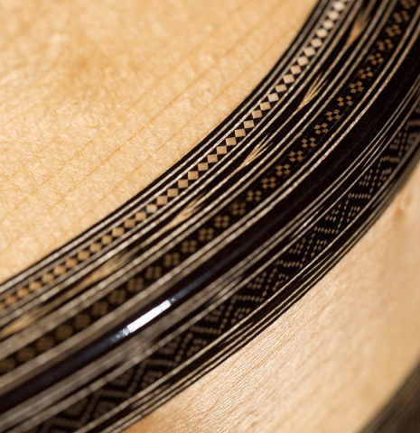 A close-up of the binding and purfling of a 2021 Gabriele Lodi "Torres" classical guitar made of spruce and maple.