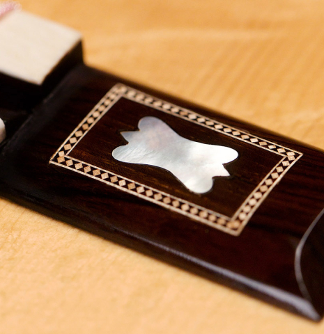 The bridge of a 2021 Gabriele Lodi "Torres" classical guitar made of spruce and maple.